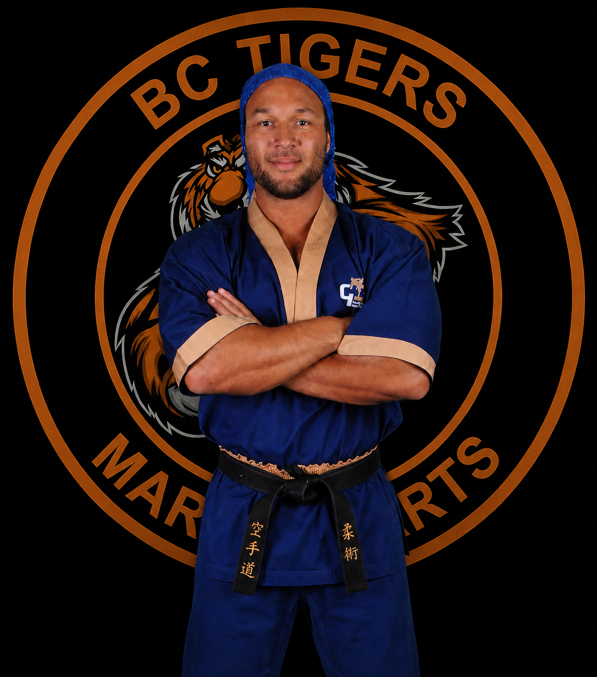 Sensei Liam, BC Tigers Martial Arts kickboxing coach, in his navy gi with arms crossed
